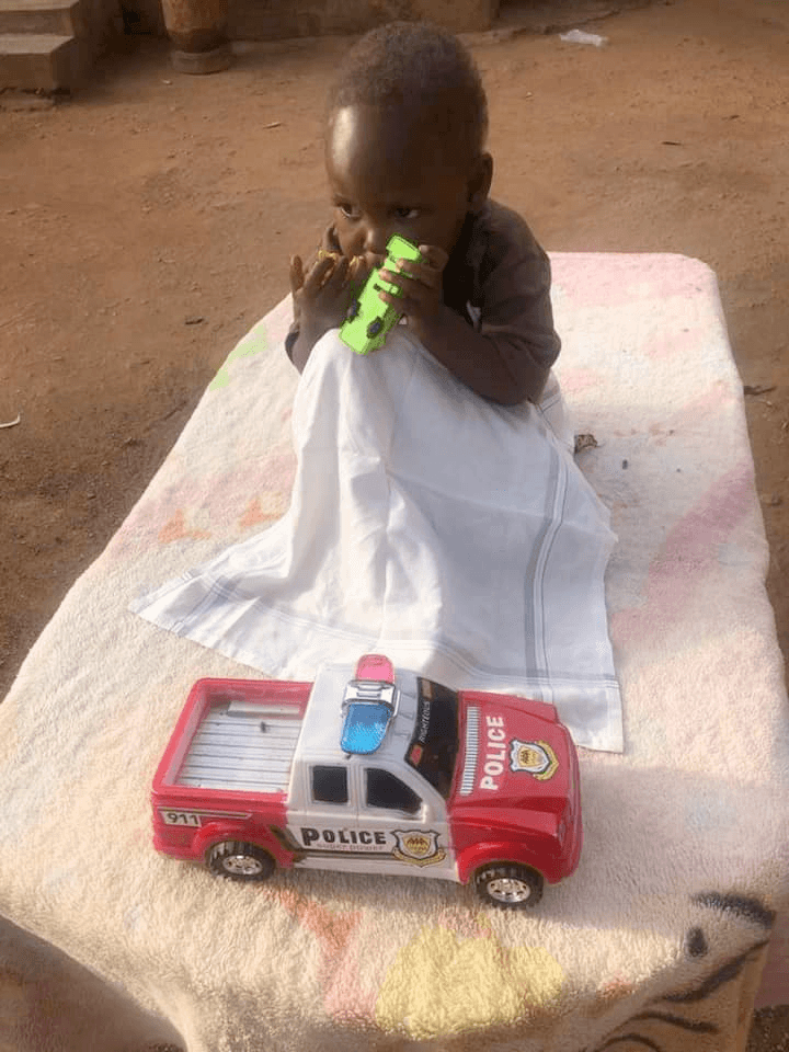 Baby Mukisa playing with a toy car