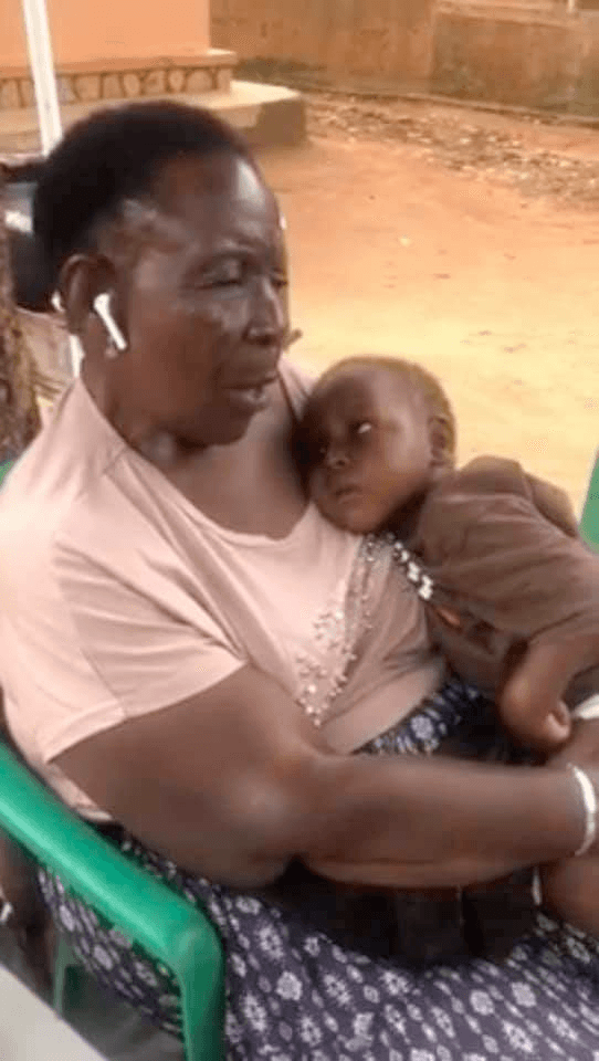 Jajja Mukyala holding Baby Mukisa when he was first brought in