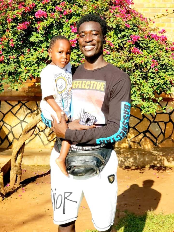 Mathew Sekanjako holding a healthy, happy Mukisa years later