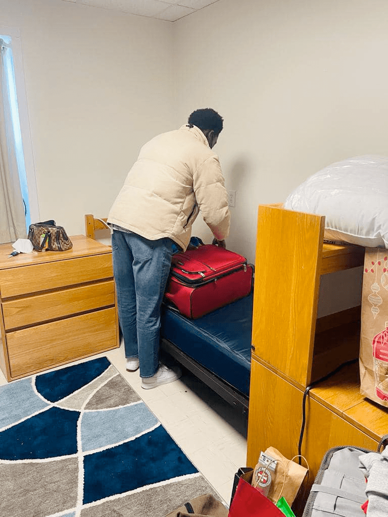 Mathew unpacking in his dorm room