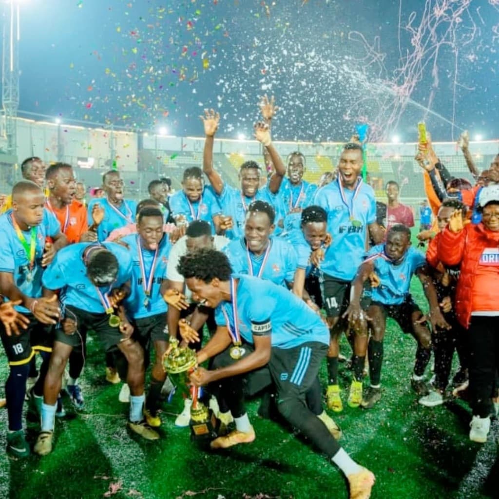 Samson celebrating with his soccer team holding a trophy